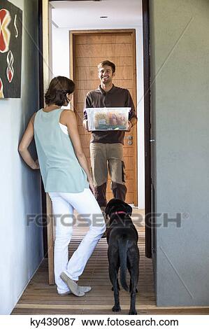 Delivery man delivering parcel to a woman View Large Photo Image Stock Photo - Delivery man delivering parcel to a woman. Fotosearch