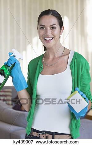 Portrait of a woman holding cleaning equipment and smiling View Large Photo Image Stock Photo - Portrait of a woman holding cleaning equipment and smiling. Fotosearch