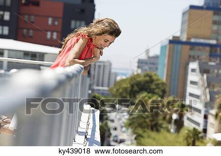 Smiling woman looking down from terrace View Large Photo Image Stock Photo - Smiling woman looking down from terrace. Fotosearch