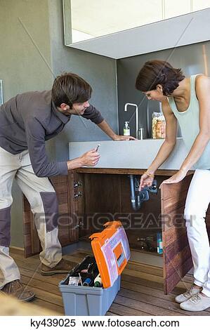 Woman discussing with a man repairing kitchen sink View Large Photo Image Stock Photography - Woman discussing with a man repairing kitchen sink. Fotosearch