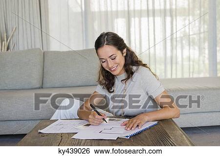 Woman doing paperwork at home View Large Photo Image Stock Photograph - Woman doing paperwork at home. Fotosearch