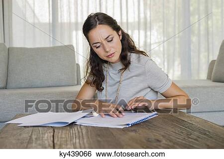 Stock Photograph - Woman doing paperwork at home. Fotosearch