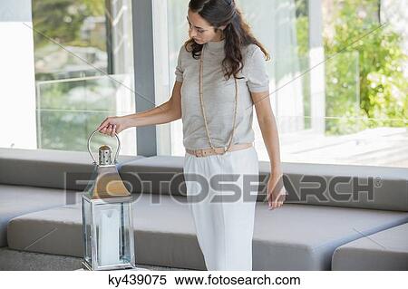 Woman holding a lantern at home View Large Photo Image Stock Photography - Woman holding a lantern at home. Fotosearch