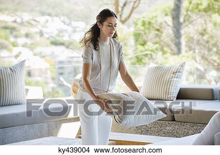 Picture - Woman holding a pillow at home. Fotosearch