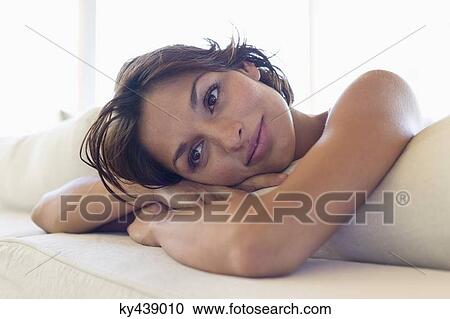 Stock Image - Woman lying on the bed and thinking. Fotosearch