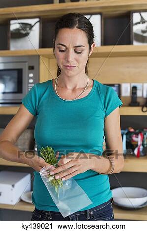Woman packing leaf vegetables for storage View Large Photo Image Stock Image - Woman packing leaf vegetables for storage. Fotosearch