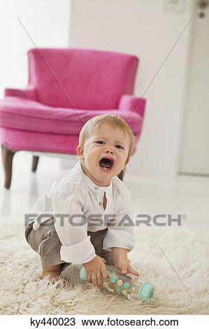 Baby boy holding a baby bottle and crying View Large Photo Image Stock Image - Baby boy holding a baby bottle and crying. Fotosearch