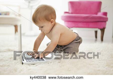 Stock Photo - Baby boy playing with a laptop. Fotosearch
