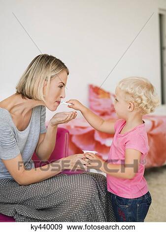 Stock Photo - Girl feeding yogurt to her mother. Fotosearch