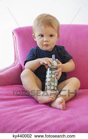 Portrait of a baby boy sitting with a baby bottle View Large Photo Image Stock Image - Portrait of a baby boy sitting with a baby bottle. Fotosearch