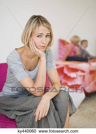 Portrait of a woman looking worried with her children in the background View Large Photo Image Stock Image - Portrait of a woman looking worried with her children in the background. Fotosearch
