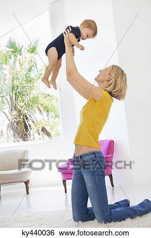 Smiling woman playing with her baby View Large Photo Image Stock Photograph - Smiling woman playing with her baby. Fotosearch