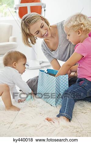 Stock Photo - Smiling woman playing with her children. Fotosearch