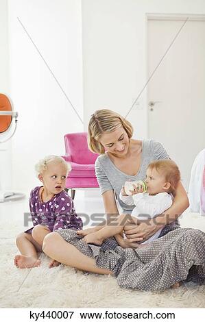 Stock Photo - Woman feeding milk her baby with a bottle. Fotosearch