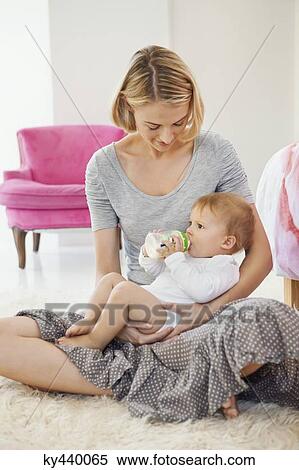 Woman feeding milk her baby with a bottle View Large Photo Image Stock Photography - Woman feeding milk her baby with a bottle. Fotosearch