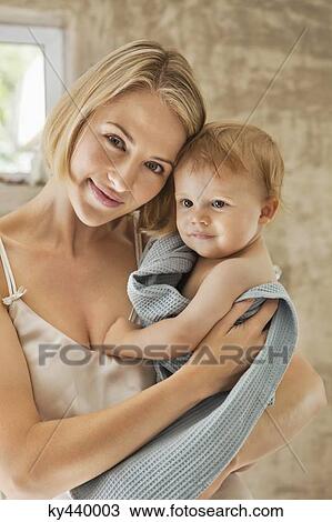 Woman holding her baby in towel View Large Photo Image Stock Image - Woman holding her baby in towel. Fotosearch