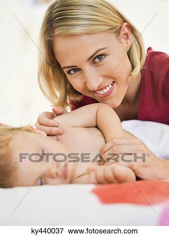 Woman near her baby sleeping on the bed View Large Photo Image Stock Photo - Woman near her baby sleeping on the bed. Fotosearch