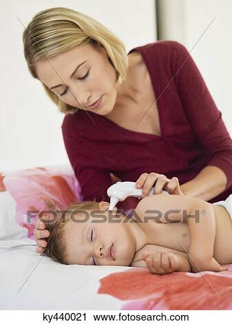 Woman taking her baby's temperature View Large Photo Image Stock Image - Woman taking her baby's temperature. Fotosearch
