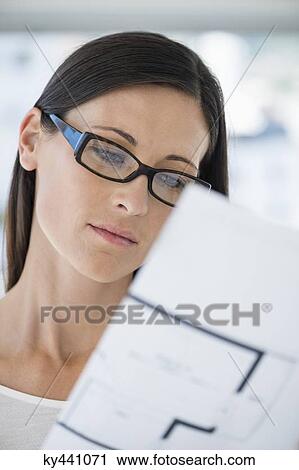 Stock Image - Close-up of a woman reading a document. Fotosearch