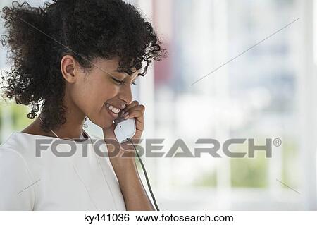 Close-up of a woman talking on a landline phone View Large Photo Image Stock Photograph - Close-up of a woman talking on a landline phone. Fotosearch