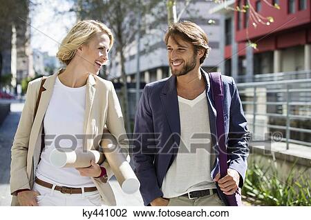 Happy couple walking on a street View Large Photo Image Stock Image - Happy couple walking on a street. Fotosearch