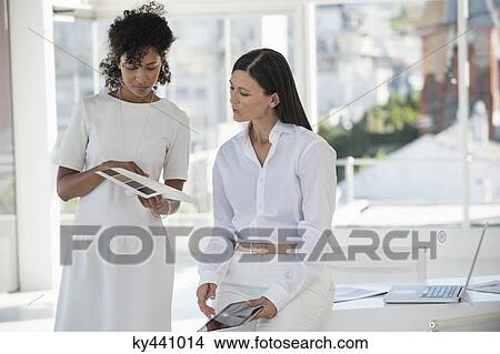Picture - Interior designer showing color swatches to a woman. Fotosearch