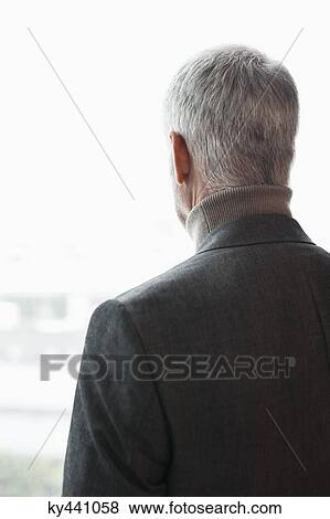Stock Photo - Man looking through a window. Fotosearch