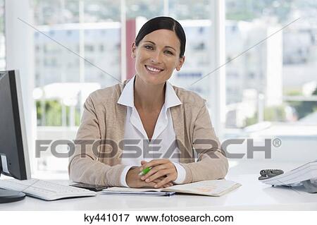 Stock Photo - Portrait of a businesswoman smiling in an office. Fotosearch