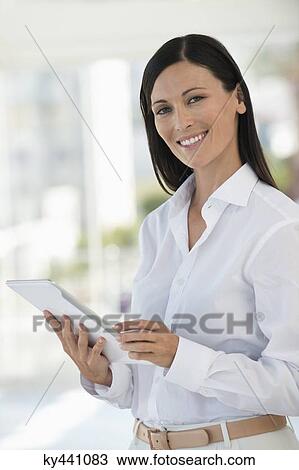 Stock Image - Portrait of a businesswoman using a digital tablet in an office. Fotosearch