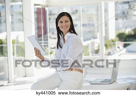 Portrait of a businesswoman using a digital tablet in an office View Large Photo Image Stock Photography - Portrait of a businesswoman using a digital tablet in an office. Fotosearch