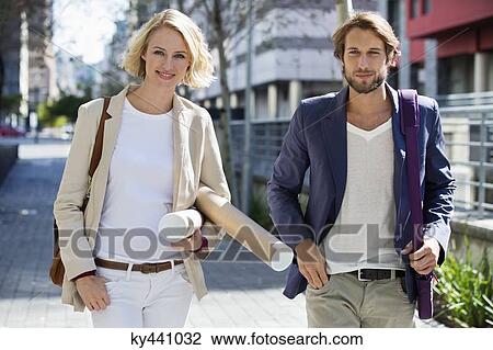 Stock Image - Portrait of a couple walking on a street. Fotosearch