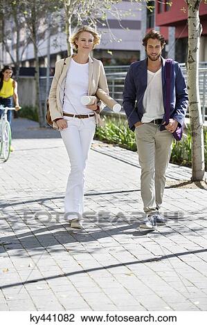 Portrait of a couple walking on a street View Large Photo Image Stock Image - Portrait of a couple walking on a street. Fotosearch