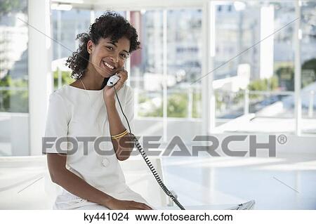 Portrait of a woman talking on a landline phone View Large Photo Image Picture - Portrait of a woman talking on a landline phone. Fotosearch