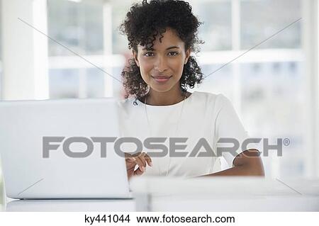 Portrait of a woman working on a laptop at home View Large Photo Image Picture - Portrait of a woman working on a laptop at home. Fotosearch