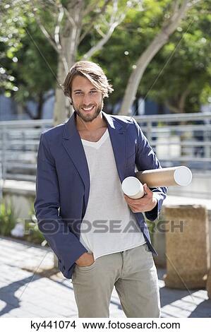 Portrait of an architect carrying paper rolls and smiling View Large Photo Image Picture - Portrait of an architect carrying paper rolls and smiling. Fotosearch