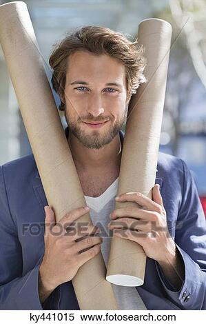Portrait of an architect holding paper rolls and smiling View Large Photo Image Stock Photography - Portrait of an architect holding paper rolls and smiling. Fotosearch