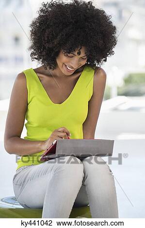 Smiling woman using a digital tablet View Large Photo Image Stock Image - Smiling woman using a digital tablet. Fotosearch