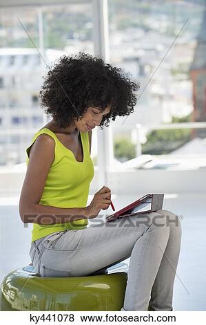 Stock Photo - Smiling woman using a digital tablet. Fotosearch