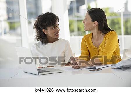 Two female smiling at each other View Large Photo Image Stock Photograph - Two female smiling at each other. Fotosearch