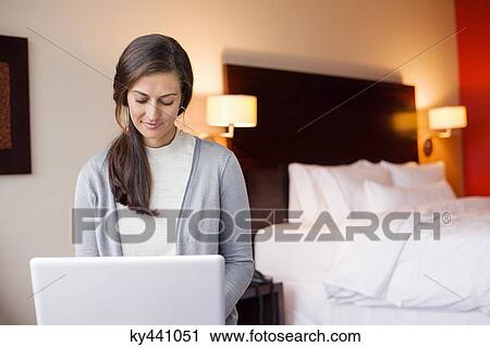 Woman using a laptop in a hotel room View Large Photo Image Stock Image - Woman using a laptop in a hotel room. Fotosearch