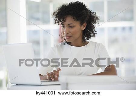 Woman working on a laptop at home View Large Photo Image Stock Image - Woman working on a laptop at home. Fotosearch