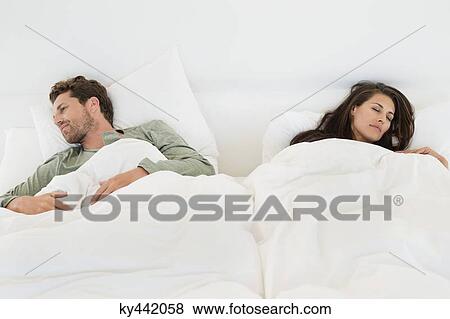 Couple sleeping on the bed View Large Photo Image Stock Photo - Couple sleeping on the bed. Fotosearch