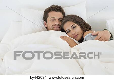 Picture - Portrait of a couple lying on the bed. Fotosearch