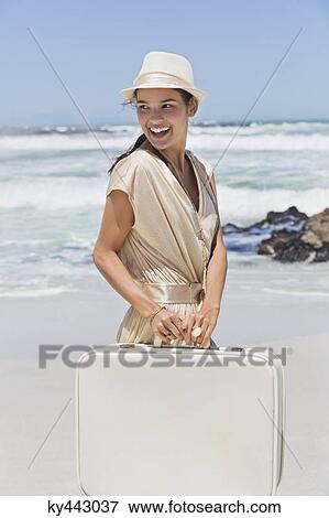 Beautiful woman carrying a suitcase on the beach View Large Photo Image Stock Photo - Beautiful woman carrying a suitcase on the beach. Fotosearch