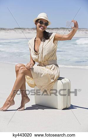 Beautiful woman taking a picture of herself with a cell phone on the beach View Large Photo Image Stock Image - Beautiful woman taking a picture of herself with a cell phone on the beach. Fotosearch