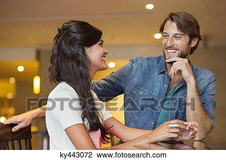 Couple smiling at each other in a bar View Large Photo Image Stock Image - Couple smiling at each other in a bar. Fotosearch