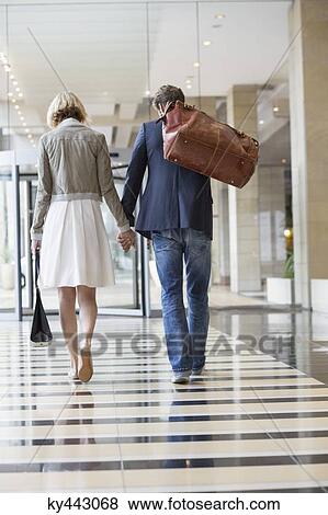 Couple walking at an airport View Large Photo Image Stock Photo - Couple walking at an airport. Fotosearch