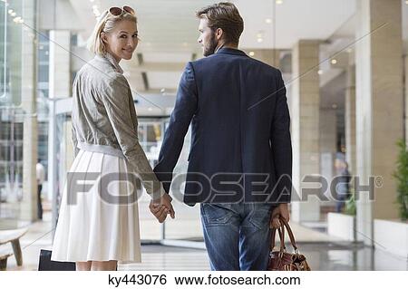 Couple walking at an airport View Large Photo Image Stock Photograph - Couple walking at an airport. Fotosearch