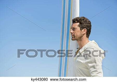 Stock Image - Man holding a surfboard. Fotosearch
