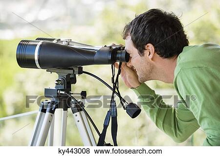 Man looking through binoculars View Large Photo Image Stock Photo - Man looking through binoculars. Fotosearch